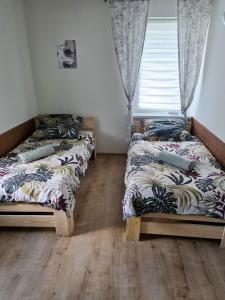 two twin beds in a room with a window at dom na gwarnej in Osłonin