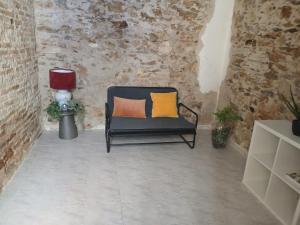 a chair with two pillows in a room with a brick wall at Casa relax Mele in Siniscola