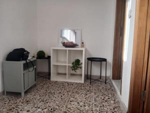 a room with a white shelf and a mirror and a stool at Casa relax Mele in Siniscola