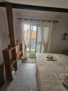 a bedroom with a bed and a large window at Villa Darche in Vrbnik