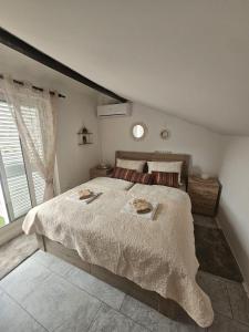 a bedroom with a large bed and a window at Villa Darche in Vrbnik