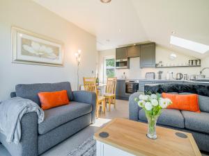 a living room with two couches and a table at Wye Nest in Fownhope