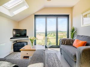 a living room with a couch and a tv at Wye Nest in Fownhope +13 photos