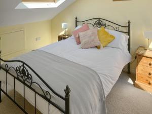 a bedroom with a bed with white sheets and pillows at Enginemans Cottage in Bishop Auckland