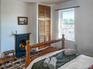 a bedroom with a bed and a fireplace in a room at Enginemans Cottage in Bishop Auckland +5 photos