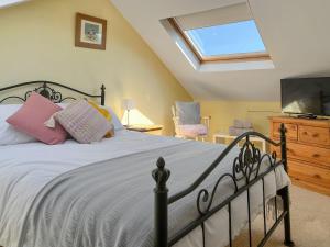 a bedroom with a large bed and a television at Enginemans Cottage in Bishop Auckland