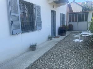 a white house with a patio with chairs and windows at Villa Alessandra in Acqui Terme