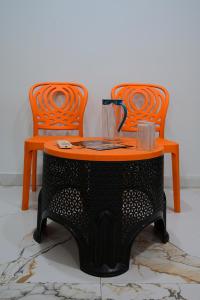 two orange chairs and a table and a table and chairs at Hotel New Residency Ayodhya in Ayodhya