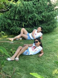 two women laying on the grass in the grass at Гостевой дом Бакай in Imeni Kirova +3 photos