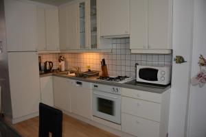 a kitchen with white cabinets and a white microwave at Royal Navy in Dunkerque