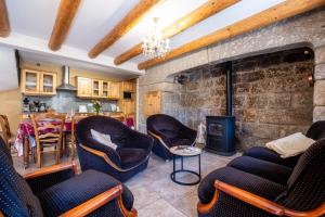 a living room with chairs and a stone wall at Digitales en margeride in SAINT DENIS EN MARGERIDE