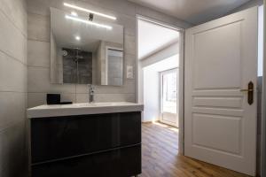 a bathroom with a sink and a mirror and a door at Digitales en margeride in SAINT DENIS EN MARGERIDE +25 photos