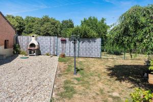 a backyard with a pizza oven next to a fence at Gite grande capacité en Puisaye in Breteau
