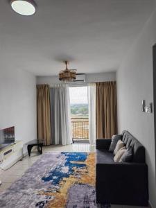 a living room with a couch and a large window at Condo Apartment RSS in Malacca