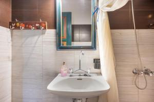 a bathroom with a sink and a mirror and a shower at Elia Cottage in Sitia