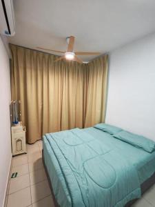 a bedroom with a blue bed and a ceiling fan at Condo Apartment RSS in Malacca