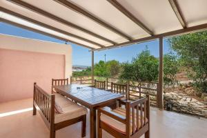 a dining room with a table and chairs on a balcony at Elia Cottage in Sitia