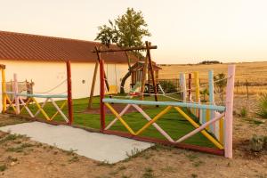 a playground in a yard with a swing at Barnhouse Duplex in Idanha-a-Nova