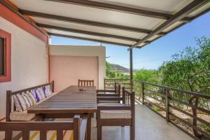 a wooden table and chairs on the balcony of a house at Elia Cottage in Sitia +15 photos