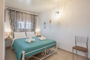 a bedroom with a bed and a chair in it at Lydia Guest House in Palekastron