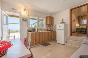 a kitchen with a white refrigerator and a table at Lydia Guest House in Palekastron