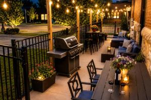 a patio with tables and chairs and a grill at Historical Boiler Maker Turns Vacation Destination in Muskegon