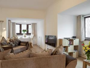 a living room with a couch and a tv at Sea Breeze in The Mumbles