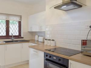 a kitchen with white cabinets and a stove top oven at Sea Breeze in The Mumbles