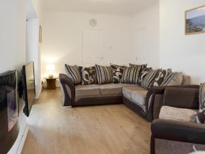 a living room with a couch and a television at Sea Breeze in The Mumbles