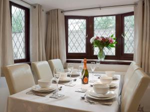 a table with white chairs and a vase of flowers at Sea Breeze in The Mumbles +7 photos