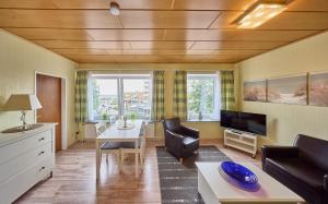 a living room with a couch and a table and a tv at Haus Schildt, FeWo 2 in Duhnen +3 photos