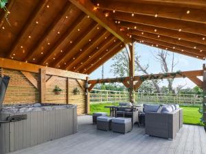 a wooden pergola with furniture and a table at 15 Chivits - Ukc8971 in Warkworth