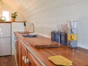 a kitchen with a wooden counter top with a refrigerator at Privet Pod - Uk41394 in Westhead