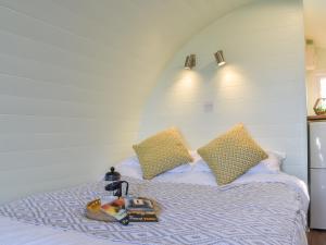 a bed with two pillows and a tray on it at Privet Pod - Uk41394 in Westhead