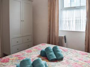 a bedroom with a bed with blue pillows on it at Seadrift in New Quay