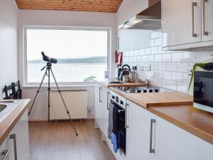 a camera on a tripod in a kitchen with a window at Seadrift in New Quay +9 photos