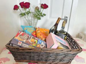 a basket filled with snacks and a bottle of wine at Leaderfoot Cottage in Selkirk