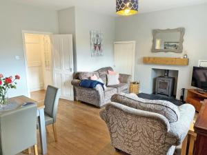 a living room with two couches and a fireplace at Leaderfoot Cottage in Selkirk