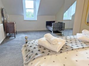 a bedroom with a bed with towels on it at Leaderfoot Cottage in Selkirk +4 photos