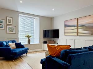 a living room with two blue couches and a flat screen tv at Stone's Throw in Richmond