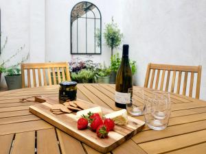 a wooden table with a bottle of wine and strawberries at Stone's Throw in Richmond +22 photos