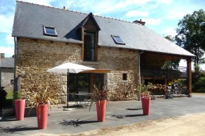 a stone building with an umbrella in front of it at L'écurie in Cohiniac