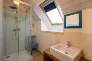 a bathroom with a glass shower and a sink at L'écurie in Cohiniac