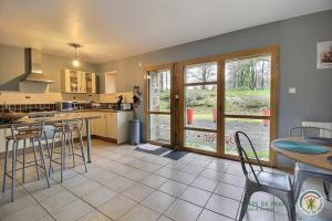 a kitchen with a counter and a table and chairs at L'écurie in Cohiniac +13 photos