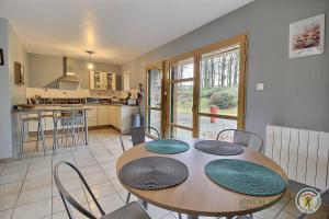 a kitchen and dining room with a table and chairs at L'écurie in Cohiniac