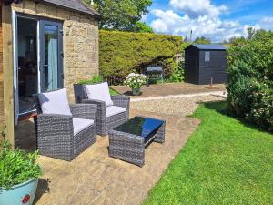 a patio with two wicker chairs and a table at The Studio At Westfield in Bellingham