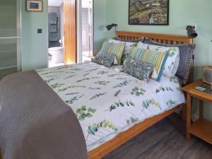 a bed with a white comforter and pillows on it at The Studio At Westfield in Bellingham