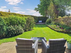 a patio with two chairs and a table in a garden at The Studio At Westfield in Bellingham +7 photos