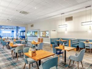 a restaurant with wooden tables and blue chairs at 178 Residences - Ukc8998 in Ilfracombe