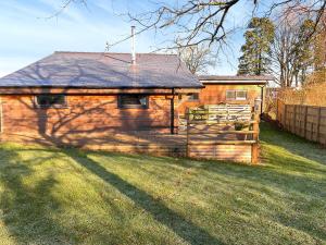 a small house with a fence in a yard at Eagle Lodge in Cowbridge